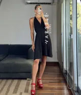 Vestido corto rojo con escote halter, espalda descubierta y falda acampanada.