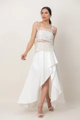 Musculosa de corte recto y tirantes anchos, confeccionada en tejido transparente de hilo de seda con Lurex, decorada con un patrón de pequeñas flores en relieve.