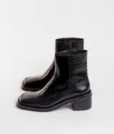 Botín de cuero con estampado de piel de serpiente en tonos blanco y negro, con puntera cuadrada y tacón bloque bajo.