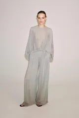 Pantalón palazzo gris de tejido semitransparente con tiro medio, cintura elástica, bolsillos laterales y forro interior corto.