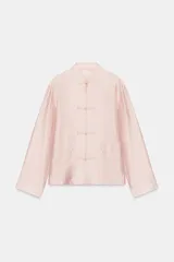 Camisa satinada de manga larga con cuello redondo y cierre frontal con alamares. Cuenta con bolsillos de plastrón en el frente y diseño de corte recto.