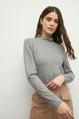 Polera gris de manga larga y cuello alto, confeccionada en tejido suave y ligero.