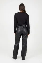 Pantalón de corte recto confeccionado en cuero sintético negro, con cierre frontal, botón y bolsillos laterales.