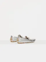 Mocasín de cuero vacuno con acabado metalizado plateado y textura tipo crocco. Presenta un aplique metálico en forma de corazón sobre el frente y suela de goma con tacos.