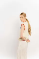 Chaleco tejido a mano en lana merino, color beige con diseño de langosta en color azul y detalles de terminación en rojo en cuello y sisas.