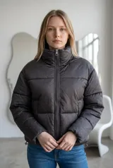 Campera puffer de corte recto y cuello alto, color gris oscuro con estampado de pequeños puntos brillantes. Cuenta con cierre frontal completo y puños elásticos.