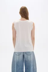 Remera blanca sin mangas con textura acanalada y corte holgado.