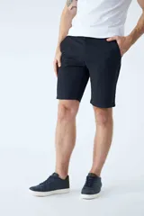 Bermuda tipo chino de gabardina color beige, con cierre de cremallera y botón, y diseño de cinco bolsillos.