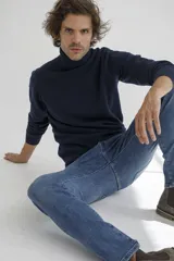 Sweater de cuello alto en color tostado, confeccionado en tejido de punto con textura en el panel frontal y mangas lisas. Presenta puños y ruedo acanalados.