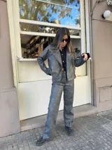 Chaqueta gris con cierre frontal y cuello solapa.