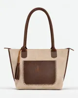 Cartera grande de cuero y gamuza, en tonos beige y chocolate, con asas largas para el hombro y bolsillo frontal con costuras artesanales.