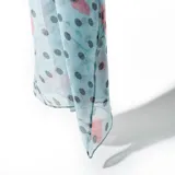Pashmina celeste estampada con lunares negros y diseño floral en tonos rosados y verdes.
