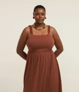 Vestido midi de Ashua confeccionado en algodón, de color marrón, con escote cuadrado, tirantes fruncidos con volados y diseño escalonado en la falda.