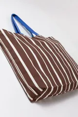 Tote bag de tela a rayas marrones y blancas con asas de hombro en color azul.