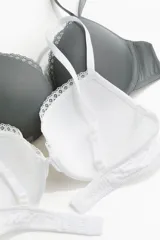 Pack de dos soutiens push-up de microfibra, uno blanco y otro gris, con breteles ajustables, copas acolchadas con aros y ribete de encaje.