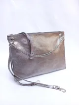 Sobre plateado de cuero con textura, cierre superior y cadena metálica decorativa. Incluye correa de cuero desmontable y regulable.