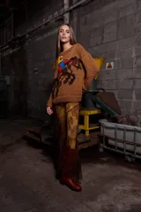 Sweater tejido de lana color marrón con bordado de un jinete a caballo. Tiene cuello redondo y puños acanalados.