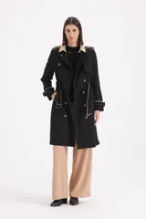 Piloto 7/8 de corte trench, color negro con detalles en beige en cuello, solapas y puños. Presenta cierre cruzado con botones, cinturón con hebilla y charreteras en los hombros.