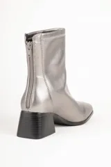 Botas de caña baja color negro, con cierre en la parte trasera, punta y taco cuadrado de 5,5cm de alto.