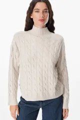 Sweater negro de punto trenzado con cuello alto.