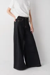 Jean de corte wide leg con tiro alto, confeccionado en denim azul. Presenta un diseño de pierna muy amplia, costuras laterales marcadas y ruedo deshilachado.