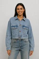 Campera de jean estilo cropped con corte holgado, cuello clásico, cierre frontal con botones metálicos y bolsillos frontales con solapa.