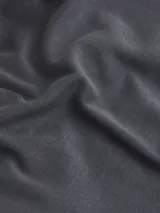 Chomba de manga corta, color gris oscuro, con cuello de polo y tapeta de tres botones. Presenta un corte ajustado al cuerpo y el logo bordado de Calvin Klein en el pecho.