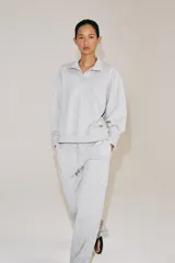 Pantalón ancho de felpa en color gris melange, con tiro medio y cintura elástica ajustable con cordón. Cuenta con bolsillos laterales ocultos en costura y diseño de pernera ancha.