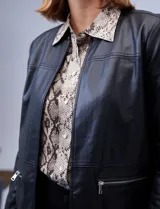 Chaqueta larga de eco cuero color negro, con cuello a la base, abertura central y bolsillos delanteros.