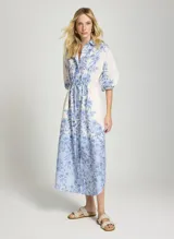 Vestido camisero midi Le Lis Blanc, con estampa floral en tonos azules sobre base blanca, cuello camisero, mangas largas abullonadas y cordón ajustable en la cintura.