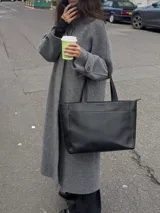 Cartera tipo tote de cuero graneado negro, con diseño clásico y espacioso. Cuenta con doble asa de hombro, bolsillo frontal con cierre magnético, bolsillo trasero con cierre metálico y compartimento principal con cierre. El interior está forrado y dispone de múltiples bolsillos organizadores.