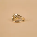 Anillo de oro 10k con diseño de nudo central y bandas laterales decoradas con circonias brillantes.