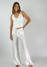 Pantalón blanco de lino con crochet en los laterales y corte acampanado.