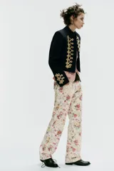 Jeans rectos de tiro medio con estampado floral multicolor sobre base blanca, trabillas para cinto, bolsillos delanteros y cierre frontal con cremallera y botón metálico.