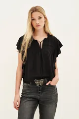 Camisa negra de viscosa con cuello redondo fruncido y escote en V con lazo. Mangas cortas con volados y detalle de frunces en el pecho.