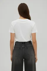 Remera de algodón color negro, de corte holgado y manga corta, con cuello a la base. Presenta un estampado frontal de una rana con sombrero vaquero y la frase 'hold on partner, im overstimulated'.