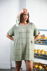 Vestido corto oversized de tejido calado en patrón cuadrado, color verde menta con terminaciones a contratono en escote y mangas. Incluye logo bordado a mano en el frente.