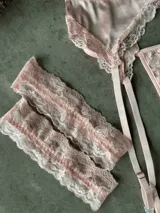 Conjunto de lencería de tres piezas color rosado, confeccionado en satén con detalles de encaje. Incluye soutiene con aro y copa armada, colaless y cinturón portaligas con tiras ajustables.