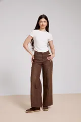 Pantalon de jean azul de corte ancho, con paneles laterales estampados con diseño floral sutil y costuras visibles.