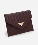 Billetera Satinato de tamaño pequeño, tipo sobre, confeccionada en PU con textura trenzada tressé de color bordó. Cuenta con solapa frontal con cierre de broche a presión y aplicación metálica triangular dorada con el logotipo de la marca.