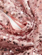 Top con cuello halter y espalda descubierta, confeccionado en tejido de lentejuelas color rosado.