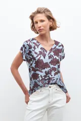 Blusa celeste con estampado floral en tonos marrones, de corte clásico, cuello en V y mangas cortas.