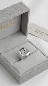 Anillo de plata 925 con diseño de ojo turco central, decorado con circonias multicolor y detalles calados en el contorno.