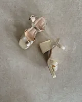 Sandalias de cuero color bronce, con taco cuadrado y tiras cruzadas en el empeine.