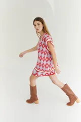 Chaleco tejido de lana con patrón de rombos en tonos lila, rojo y beige, con cuello en V y ribetes en color crema. Diseño oversize.