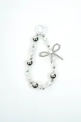 Llavero decorativo con cuentas metálicas plateadas, perlas sintéticas, abalorios transparentes facetados y un dije en forma de lazo con cuentas. Incluye un anillo superior para su sujeción.