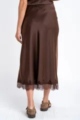 Falda midi negra de acabado satinado, corte al bies, con detalle de encaje en el ruedo.