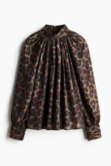 Blusa de manga larga oversized con estampado de leopardo, cuello elevado drapeado con frunces y puños anchos con botones forrados.