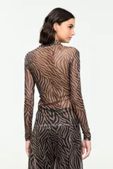 Blusa de tul semitransparente con estampado animal print tipo cebra en tonos marrón y negro, cuello alto y mangas largas.