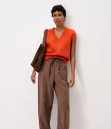 Pantalón carrot color marrón de modelado suelto en la cadera con barra afinada, cintura elástica con amarre ajustable y bolsillos.